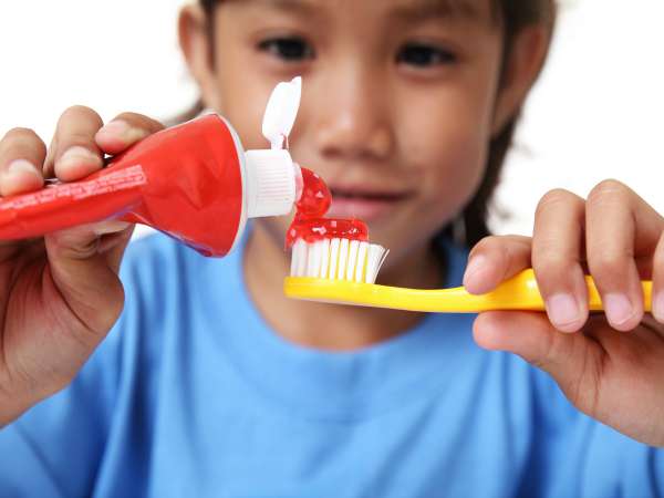 Los niños ponen mucha pasta de dientes en el cepillo y puede ser